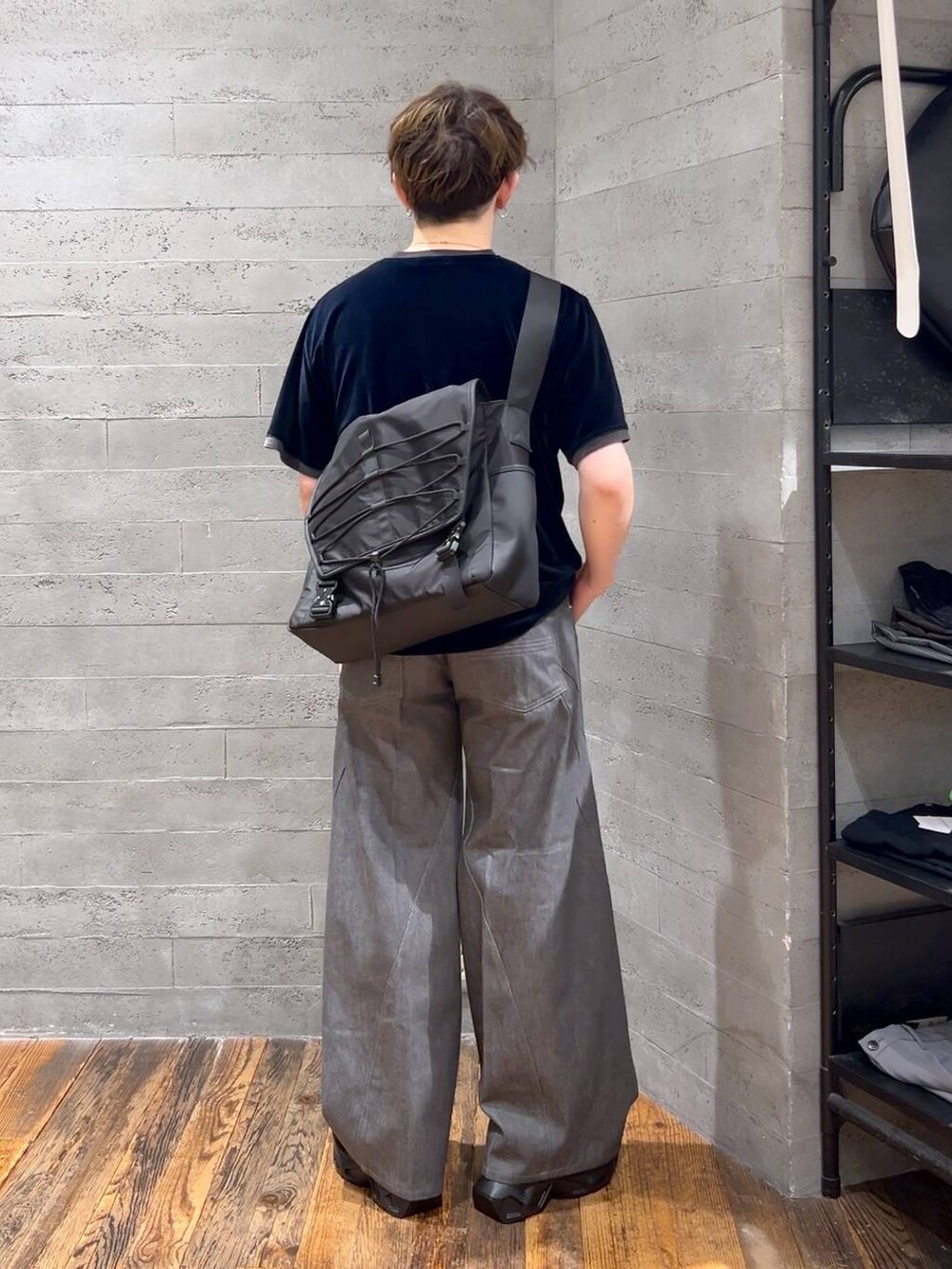 グレー系のデニムパンツ、ブラック系のサンダル、ブラック系のメッセンジャーバッグを着用したメンズの夏コーディネートの3枚目の写真