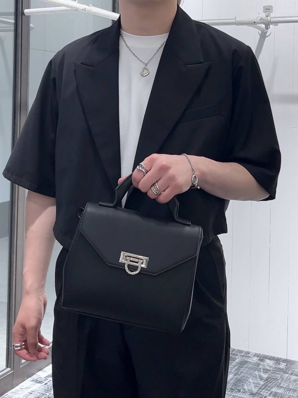 ホワイト系のTシャツ/カットソー、ブラック系のドレスシューズ、ブラック系のショルダーバッグを着用したメンズの春コーディネートの5枚目の写真