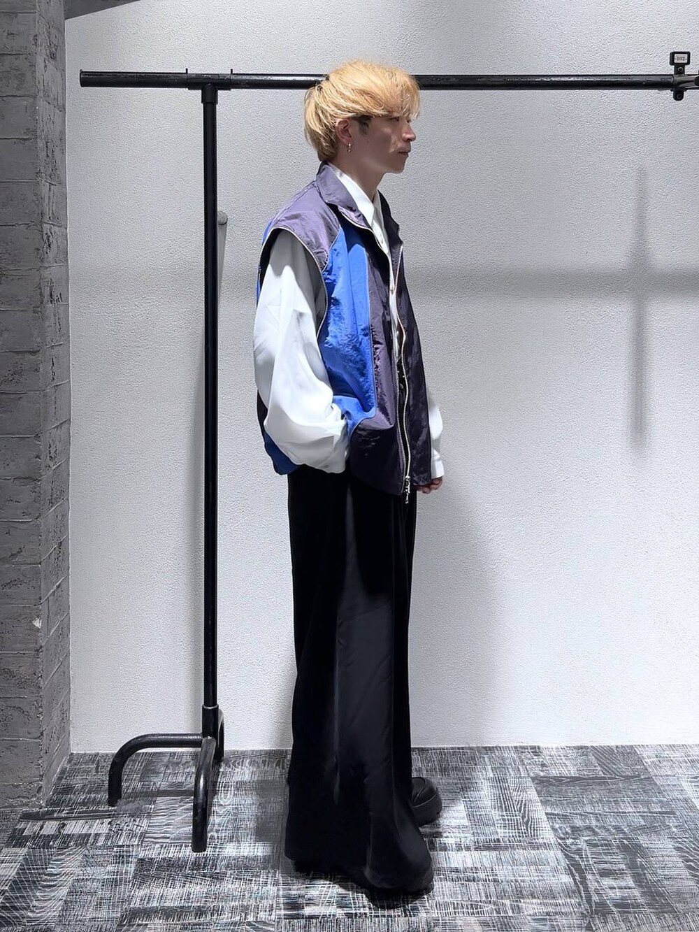 ブラック系のスラックス、ホワイト系のシャツ/ブラウス、ブラック系のブーツを着用したメンズの冬コーディネートの3枚目の写真