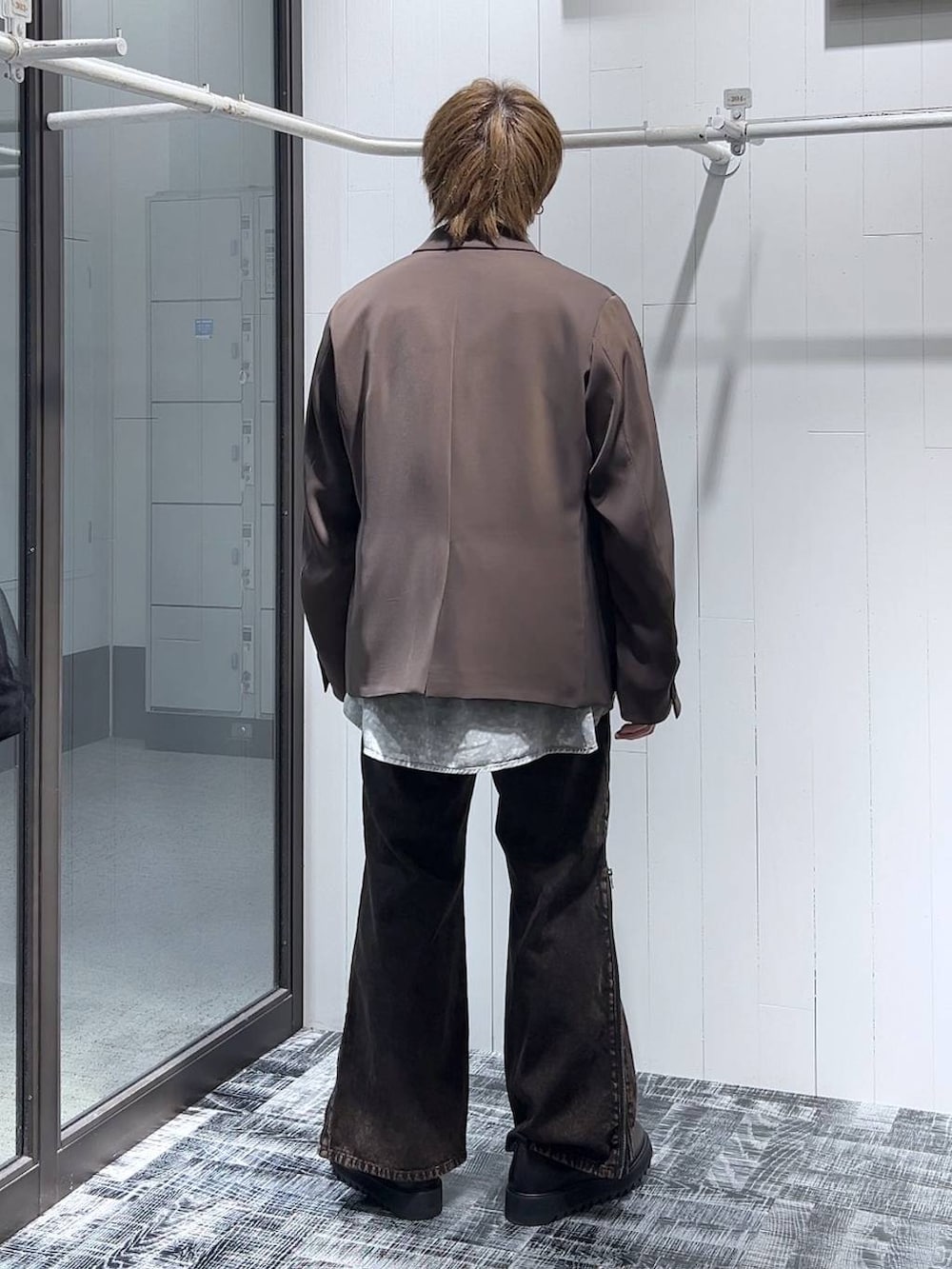 オレンジ系のデニムパンツ、ブラウン系のテーラードジャケット、ブラック系のドレスシューズを着用したメンズの春コーディネートの3枚目の写真