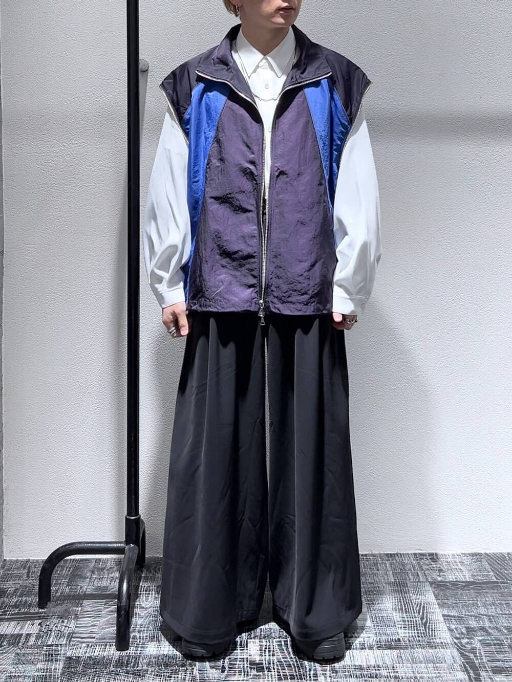 ブラック系のスラックス、ホワイト系のシャツ/ブラウス、ブラック系のブーツを着用したメンズの冬コーディネートの2枚目の写真