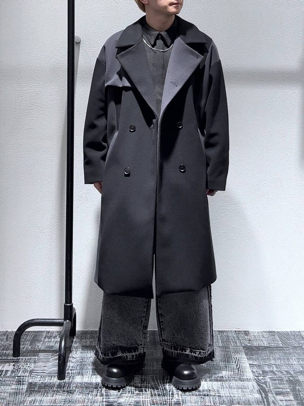 ブラック系のその他パンツ、ブラック系のブーツ、ブラック系のステンカラーコートを着用したメンズの冬コーディネートの2枚目の写真