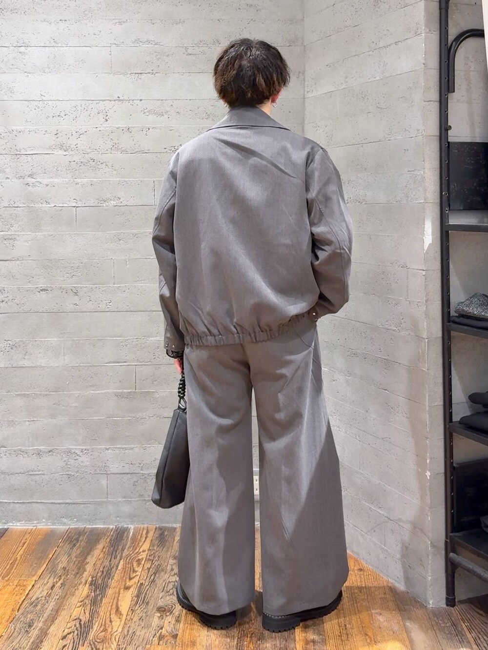 グレー系のスラックス、ブラック系のシャツ/ブラウス、ブラック系のブーツを着用したメンズの秋コーディネートの3枚目の写真