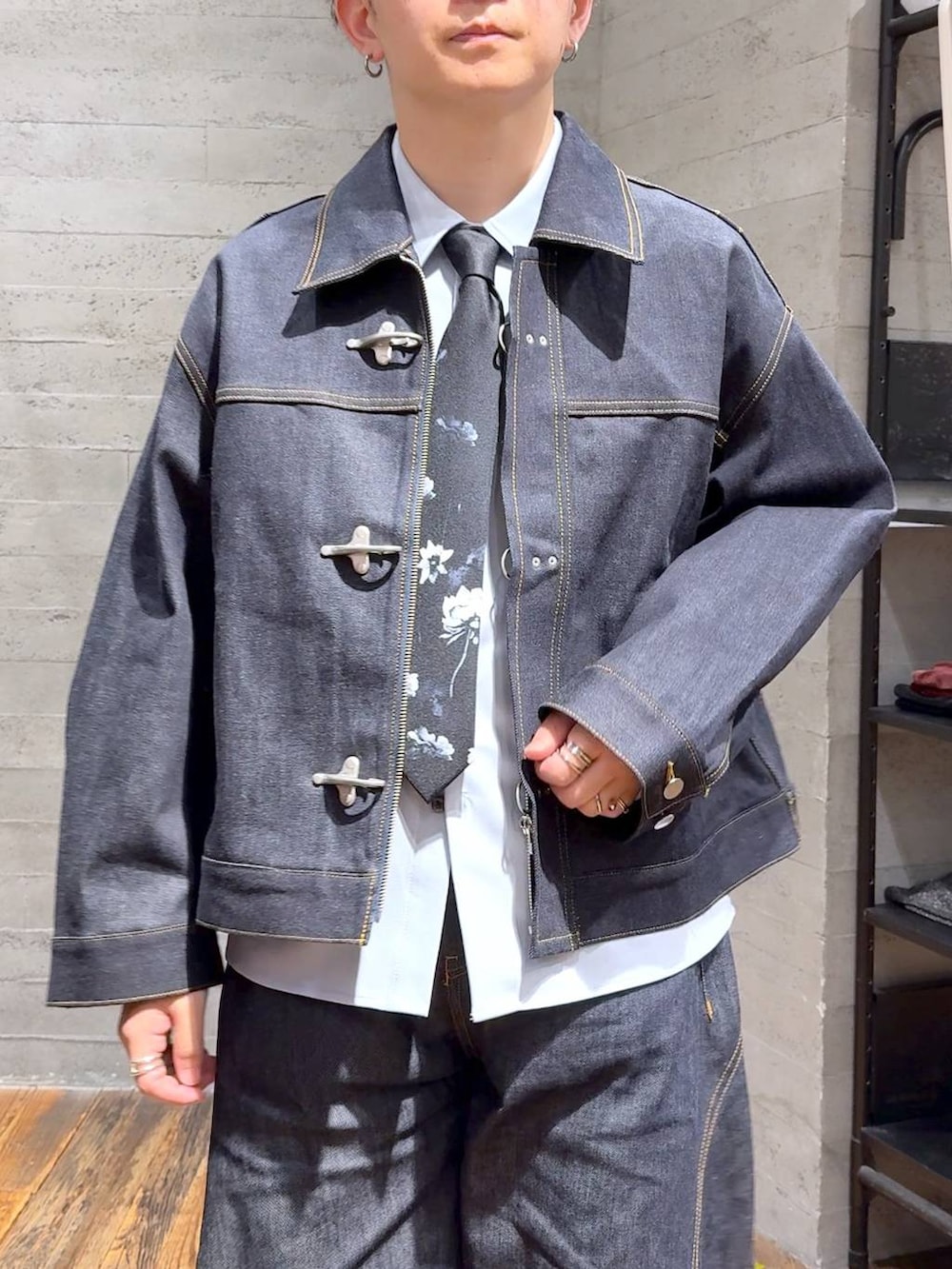 ブルー系のデニムパンツ、ブラック系のネクタイ、ブラック系のローファーを着用したメンズの秋コーディネートの4枚目の写真