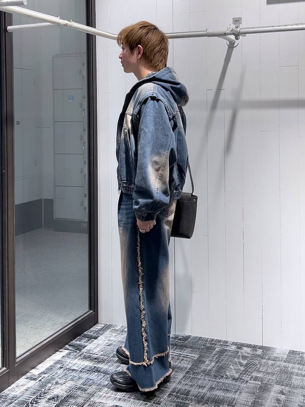 ブルー系のデニムパンツ、グレー系のショルダーバッグ、ホワイト系のTシャツ/カットソーを着用したメンズの冬コーディネートの4枚目の写真