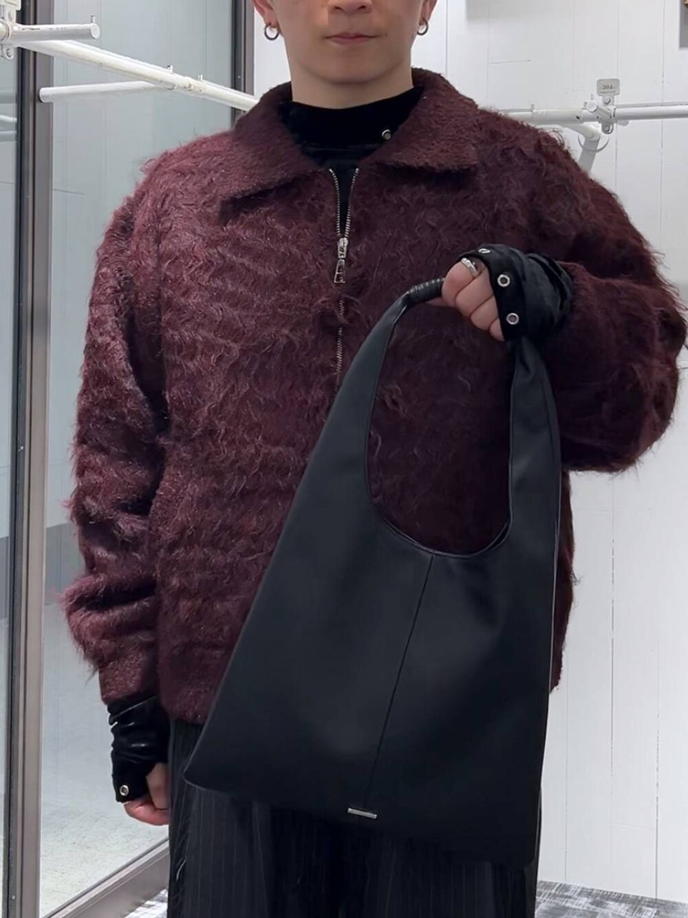 ブラック系のトートバッグ、ブラック系のTシャツ/カットソー、ブラック系のその他パンツを着用したメンズの冬コーディネートの5枚目の写真
