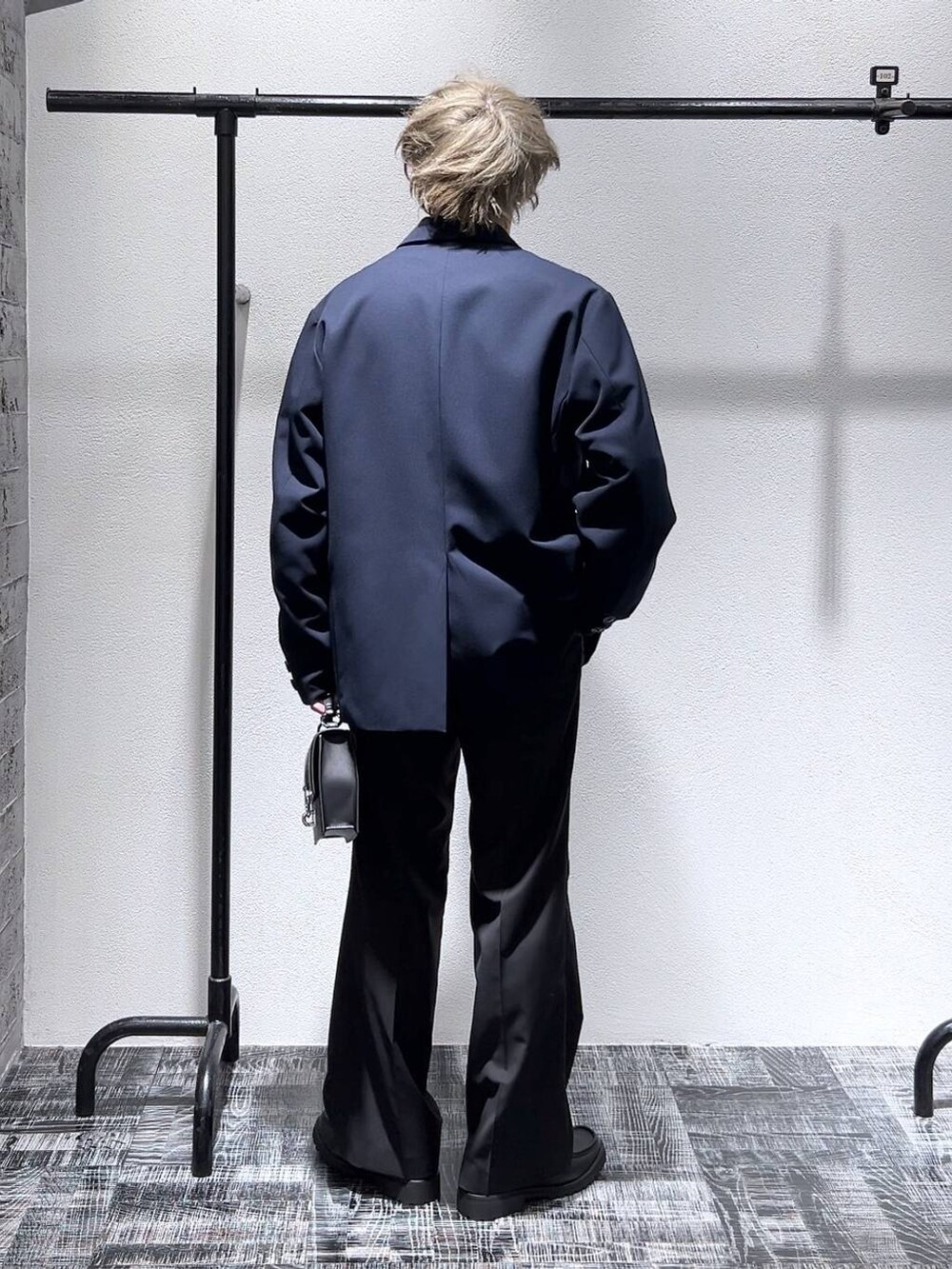 ブルー系のテーラードジャケット、ブラック系のスラックス、ブルー系のスウェットを着用したメンズの冬コーディネートの4枚目の写真