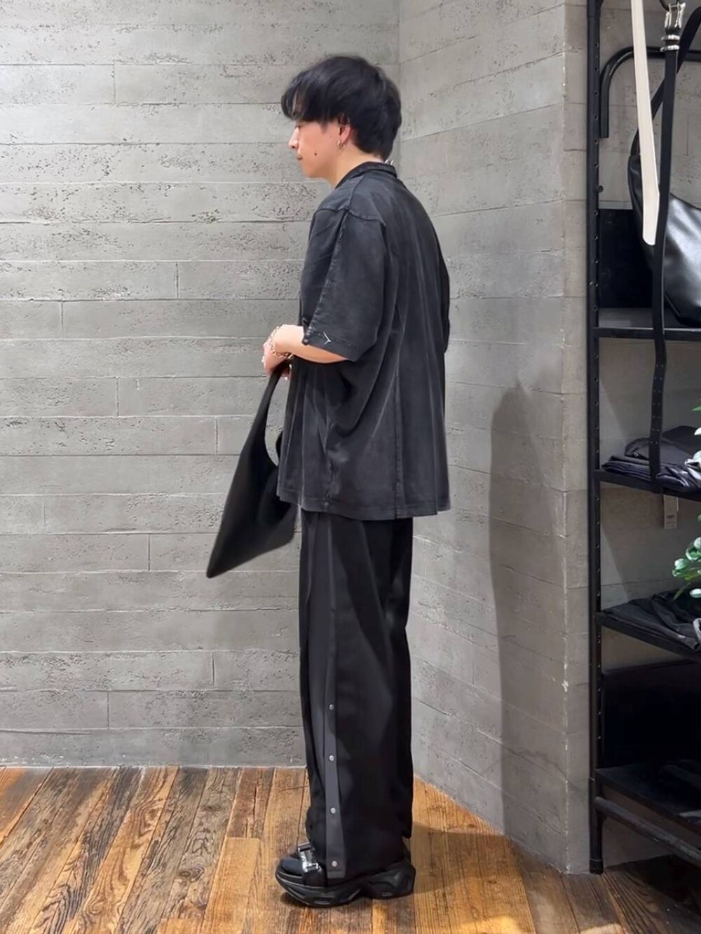 ブラック系のトートバッグ、ブラック系のサンダル、ブラック系のTシャツ/カットソーを着用したメンズの春コーディネートの4枚目の写真
