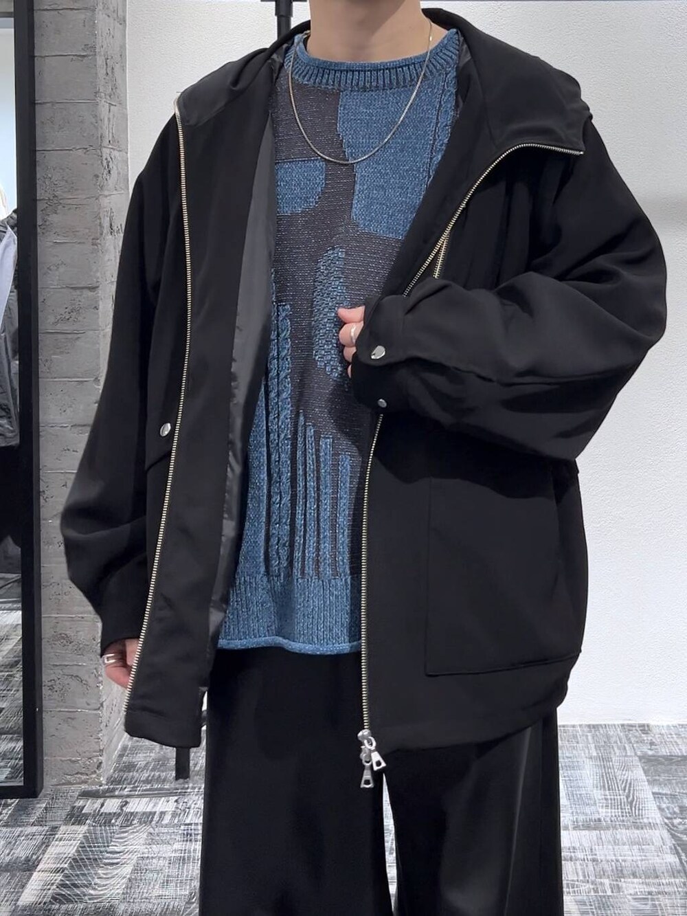 ブルー系のニット/セーター、ブラック系のその他パンツ、ブラック系のスニーカーを着用したメンズの冬コーディネートの5枚目の写真