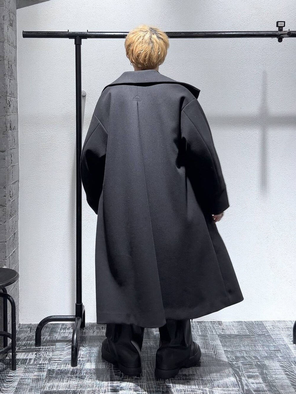 ブラック系のショルダーバッグ、ブラック系のカーゴパンツ、ブラック系のステンカラーコートを着用したメンズの冬コーディネートの4枚目の写真