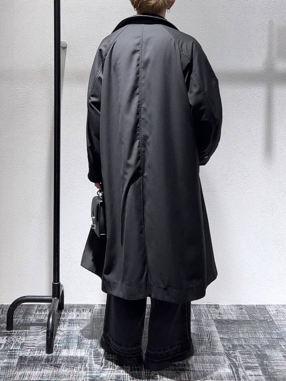 ブラック系のデニムパンツ、ブラック系のショルダーバッグ、グリーン系のニット/セーターを着用したメンズの秋コーディネートの3枚目の写真