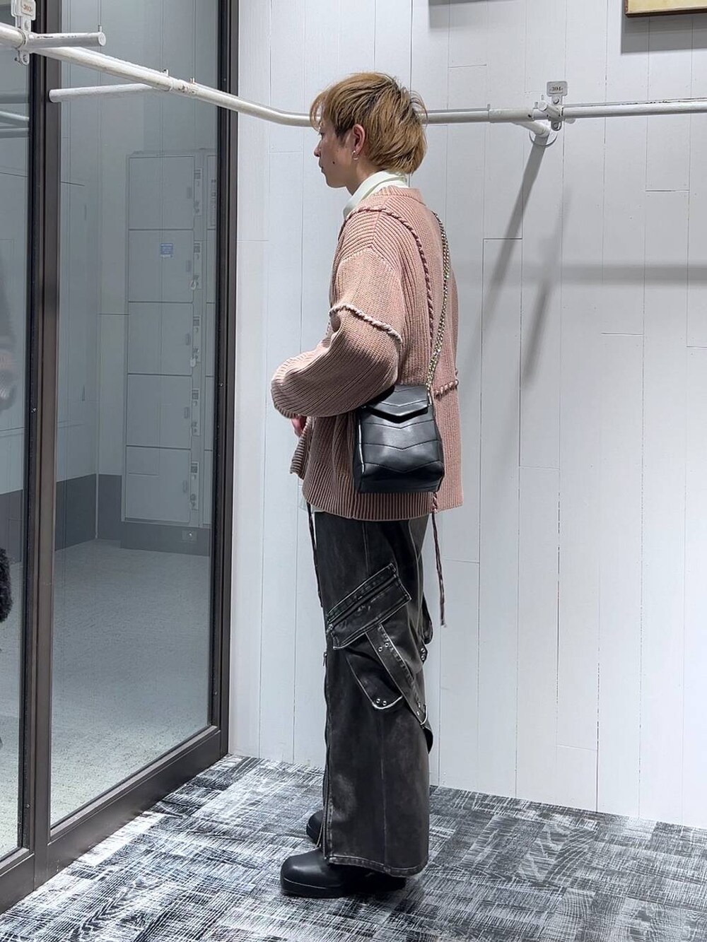 グレー系のカーゴパンツ、ブラック系のショルダーバッグ、ピンク系のカーディガン/ボレロを着用したメンズの冬コーディネートの4枚目の写真