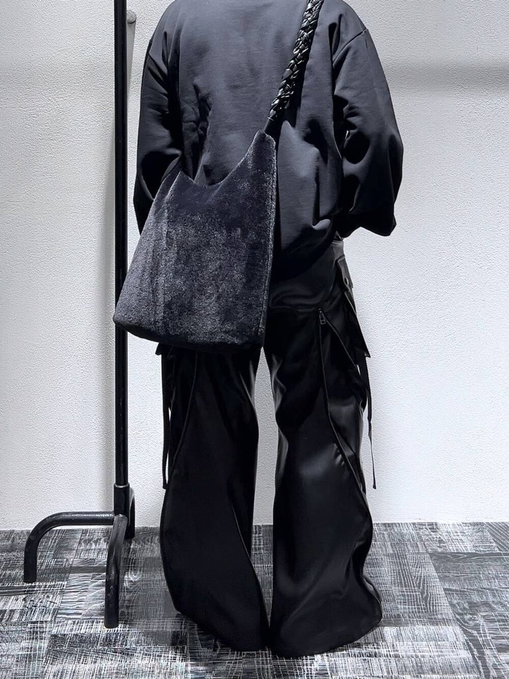 ブラック系のドレスシューズ、ブラック系のスウェット、ブラック系のショルダーバッグを着用したメンズの冬コーディネートの4枚目の写真