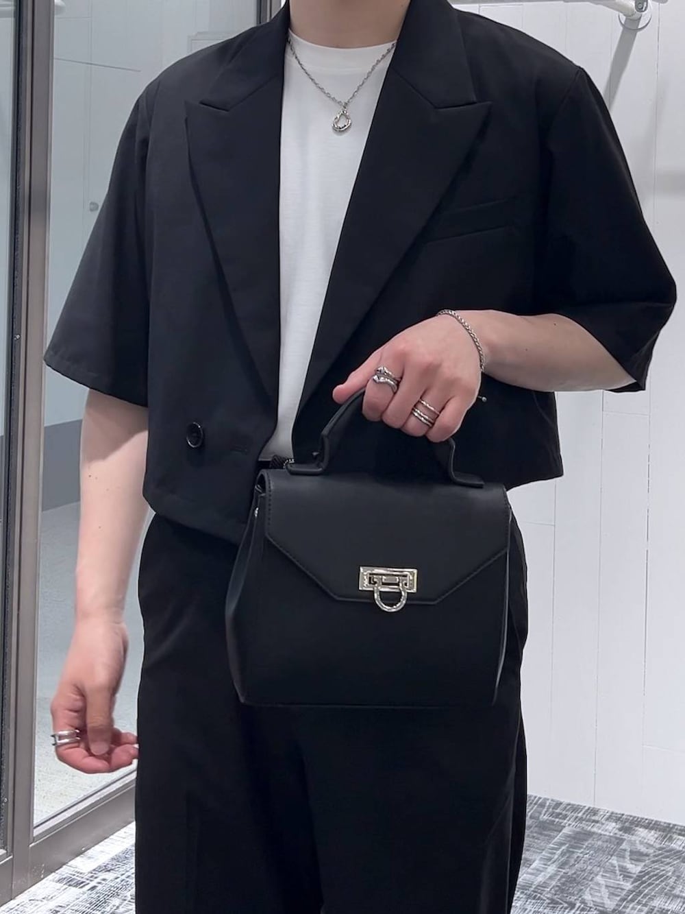 ホワイト系のTシャツ/カットソー、ブラック系のドレスシューズ、ブラック系のショルダーバッグを着用したメンズの春コーディネートの4枚目の写真