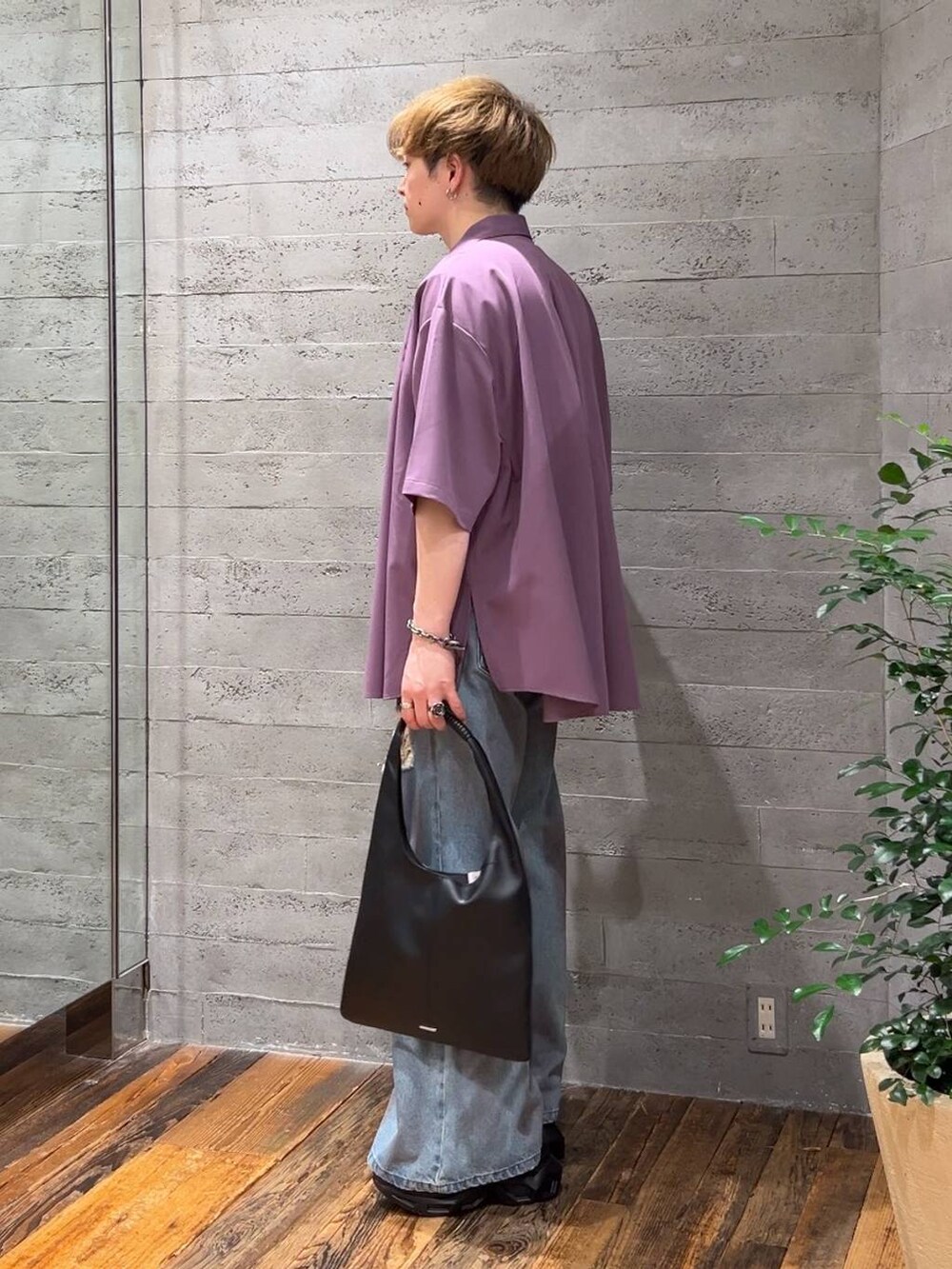ブラック系のトートバッグ、ブルー系のデニムパンツ、ブラック系のサンダルを着用したメンズの夏コーディネートの4枚目の写真