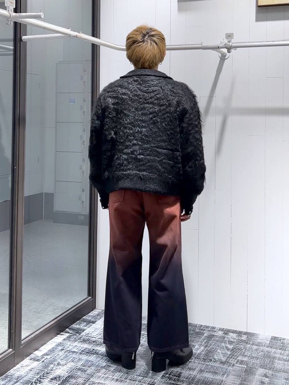 オレンジ系のデニムパンツ、ブラック系のTシャツ/カットソー、ブラック系のブーツを着用したメンズの冬コーディネートの3枚目の写真