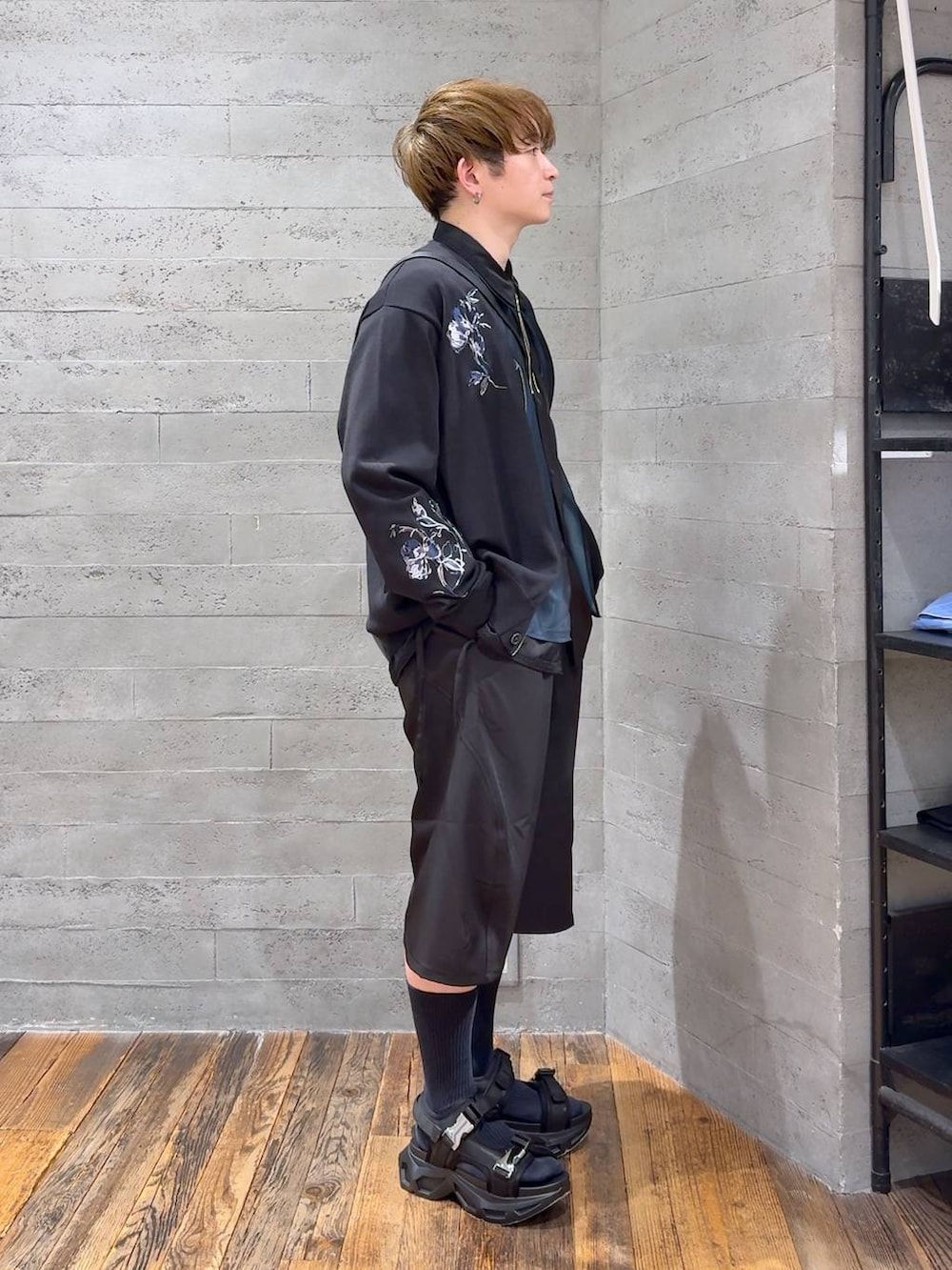 ブラック系のサンダル、ブラック系のスラックス、ブラック系のショルダーバッグを着用したメンズの春コーディネートの2枚目の写真