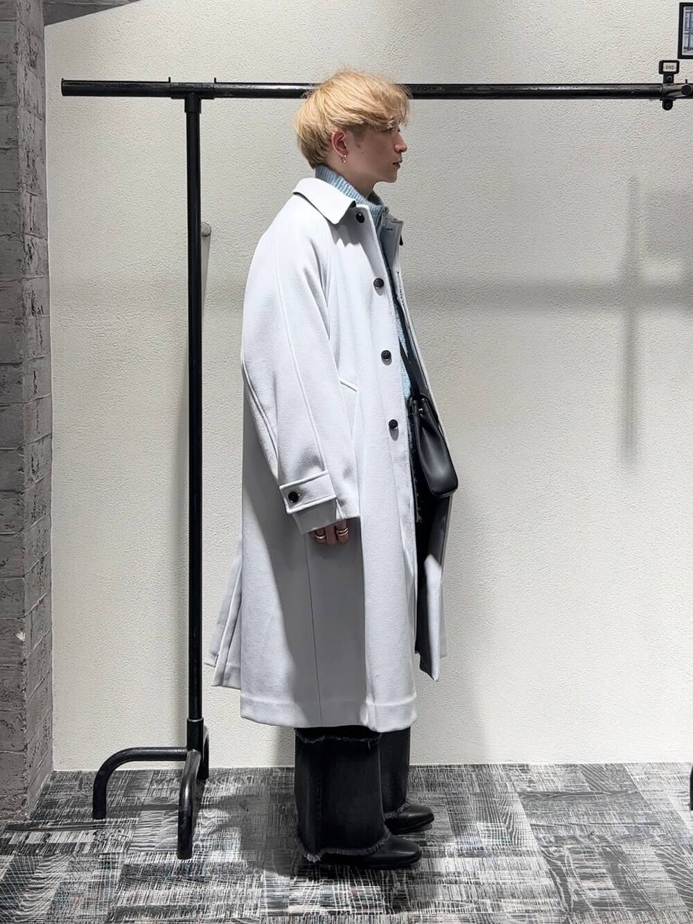 ブラック系のドレスシューズ、グレー系のステンカラーコート、ブラック系のショルダーバッグを着用したメンズの秋コーディネートの3枚目の写真