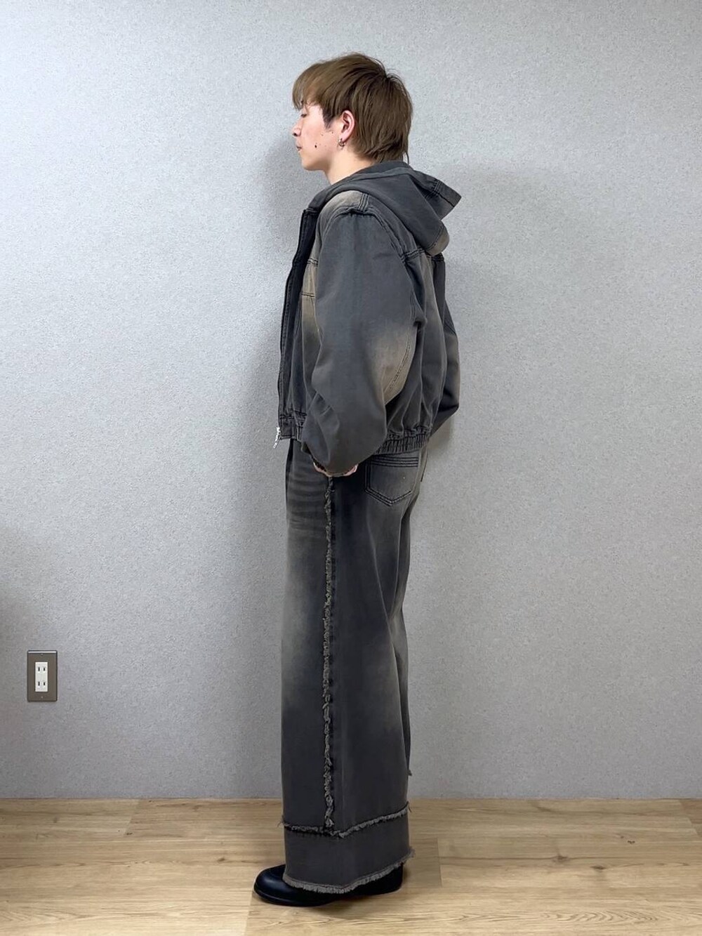 ブラウン系のデニムパンツ、ブラック系のドレスシューズ、シルバー系のネックレスを着用したメンズの冬コーディネートの4枚目の写真