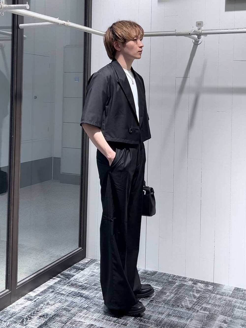 ホワイト系のTシャツ/カットソー、ブラック系のドレスシューズ、ブラック系のショルダーバッグを着用したメンズの春コーディネートの4枚目の写真