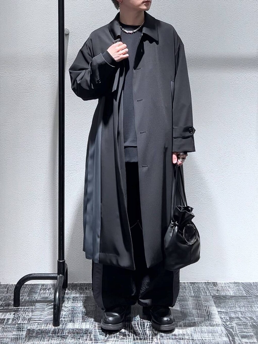 ブラック系のスウェット、ブラック系のステンカラーコート、ブラック系のドレスシューズを着用したメンズの冬コーディネートの2枚目の写真