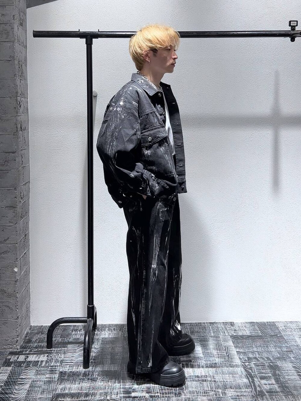 グレー系のスウェット、ブラック系のブーツ、ブラック系のデニムジャケットを着用したメンズの冬コーディネートの3枚目の写真