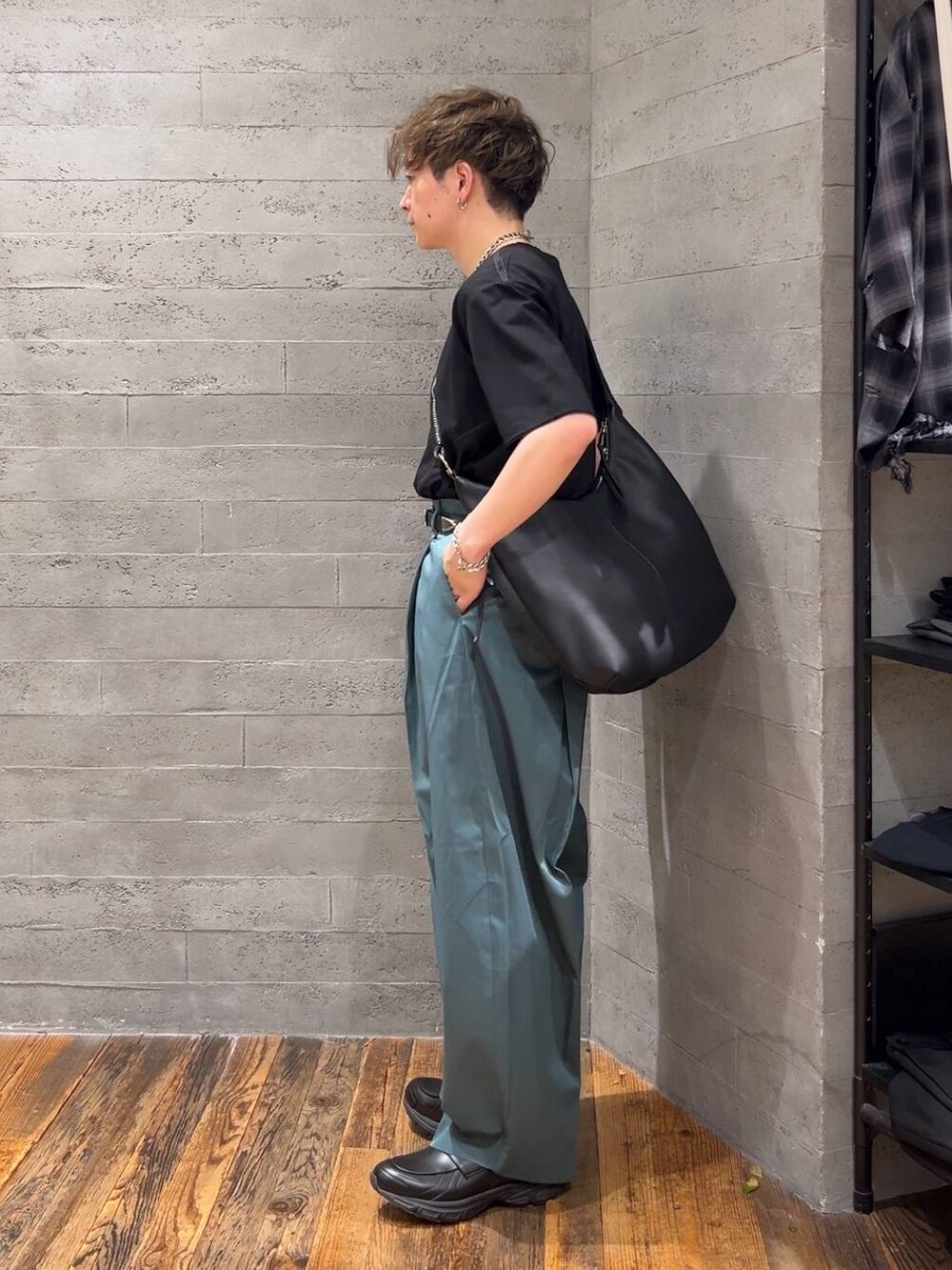 ブラック系のローファー、ブラック系のショルダーバッグ、グリーン系のチノパンツを着用したメンズの夏コーディネートの4枚目の写真