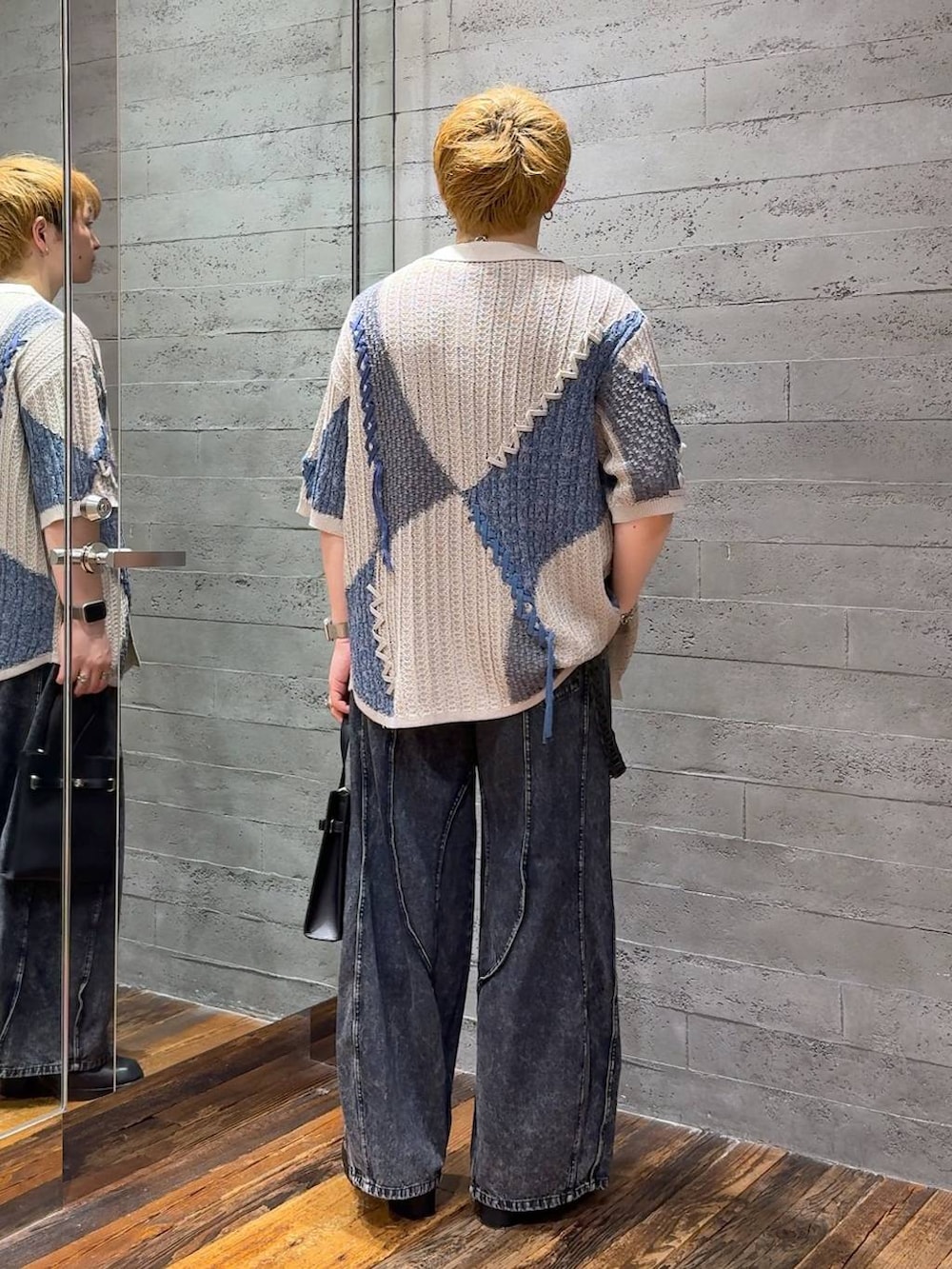 ブルー系のデニムパンツ、ブラック系のTシャツ/カットソー、ブラック系のサンダルを着用したメンズの夏コーディネートの3枚目の写真