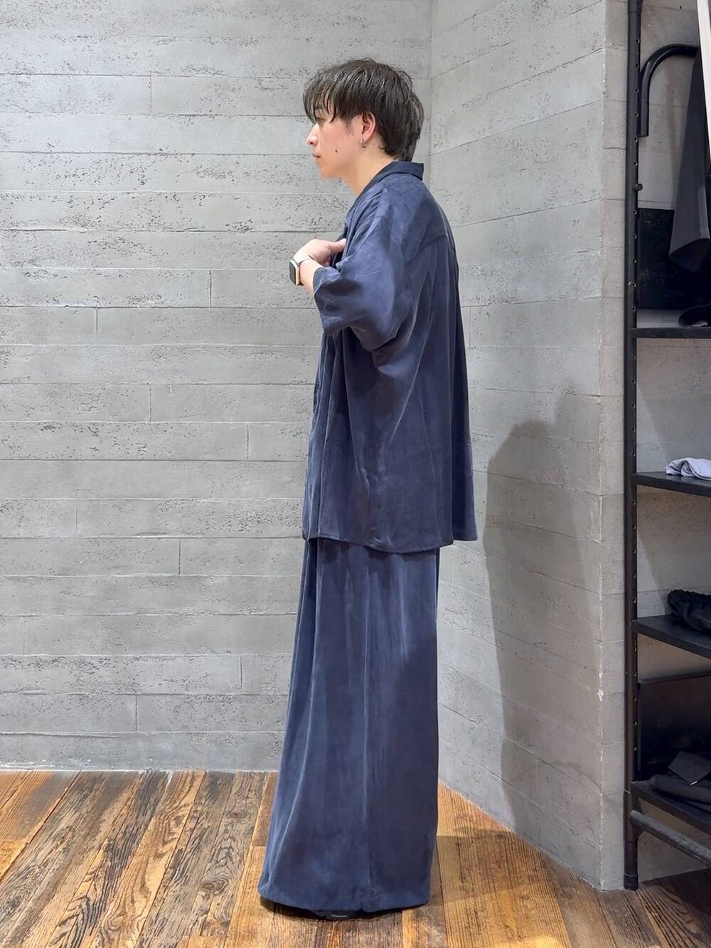 ブルー系のスラックス、ブラック系のサンダル、ホワイト系のTシャツ/カットソーを着用したメンズの夏コーディネートの4枚目の写真