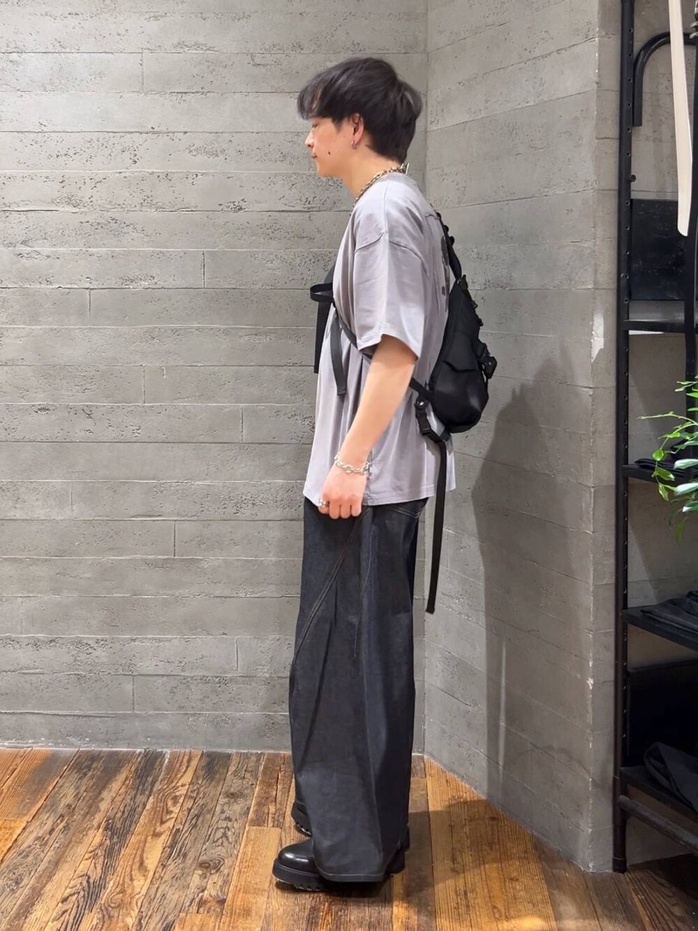 ブルー系のデニムパンツ、ブラック系のショルダーバッグ、グレー系のTシャツ/カットソーを着用したメンズの春コーディネートの4枚目の写真
