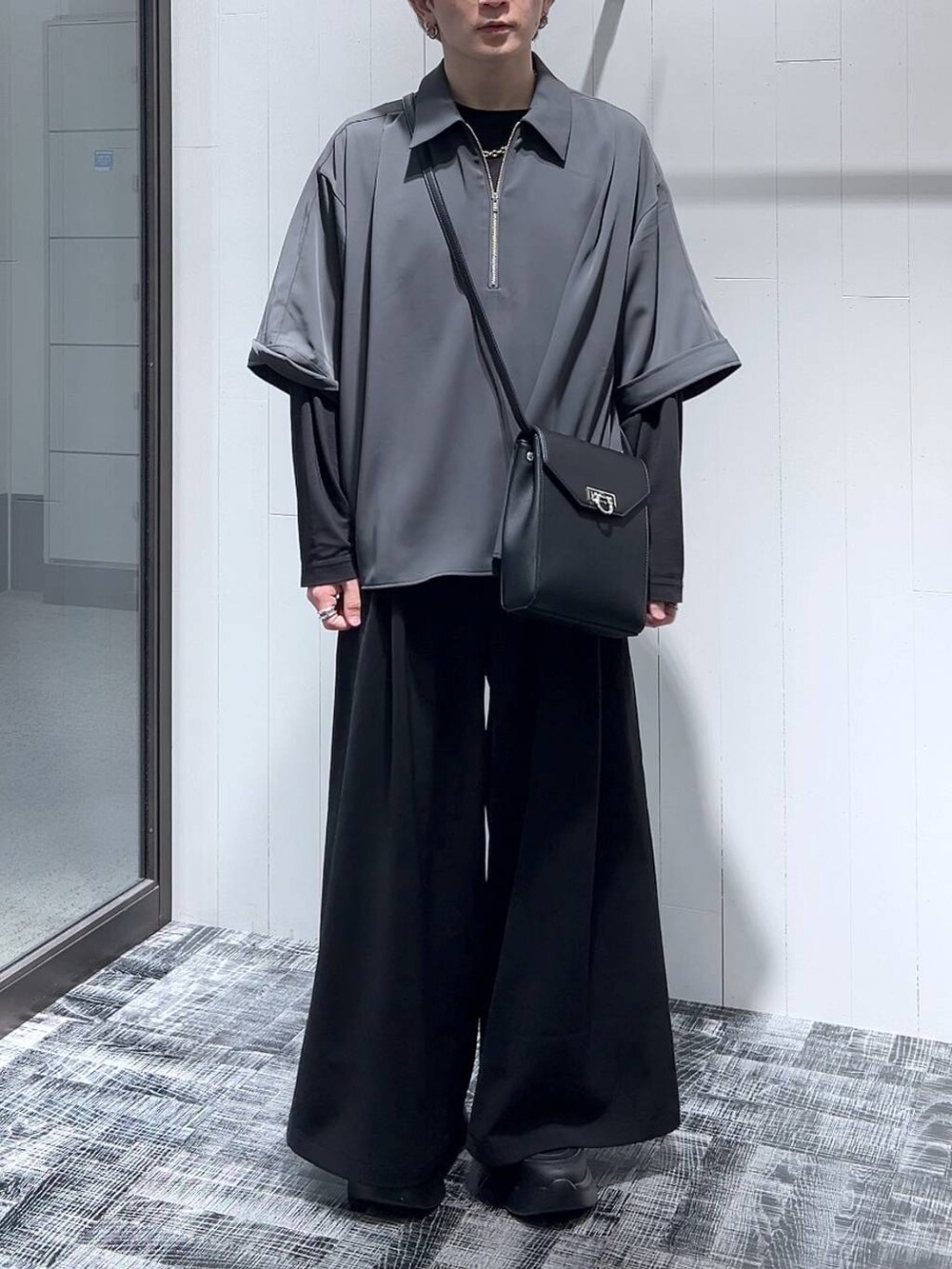 ブラック系のTシャツ/カットソー、ブラック系のショルダーバッグ、ブラック系のスラックスを着用したメンズの春コーディネートの2枚目の写真