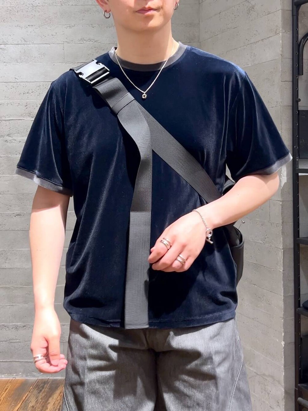 グレー系のデニムパンツ、ブラック系のサンダル、ブラック系のメッセンジャーバッグを着用したメンズの夏コーディネートの5枚目の写真