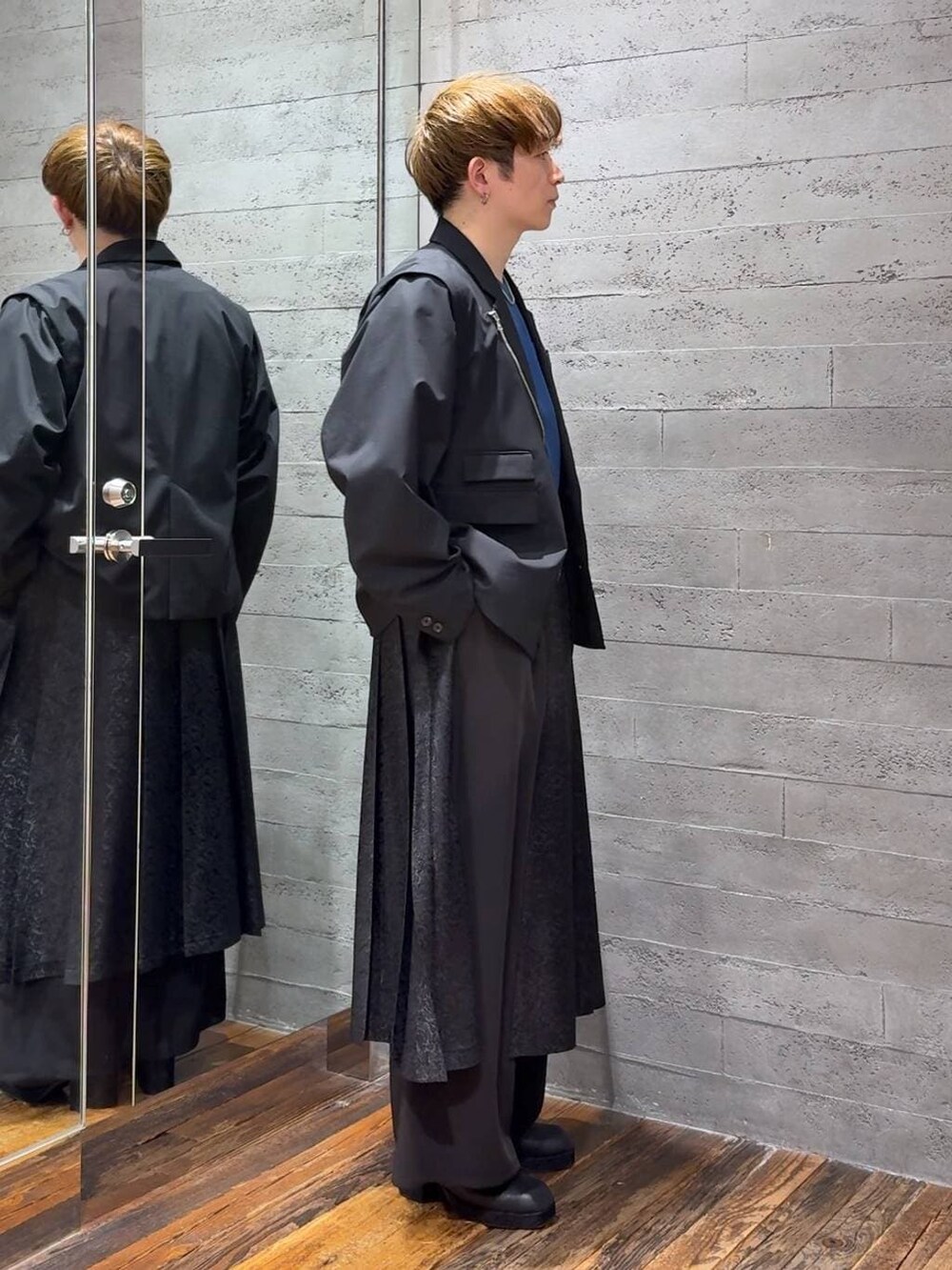 ブルー系のTシャツ/カットソー、ブラック系のサンダル、ブラック系のテーラードジャケットを着用したメンズの春コーディネートの2枚目の写真