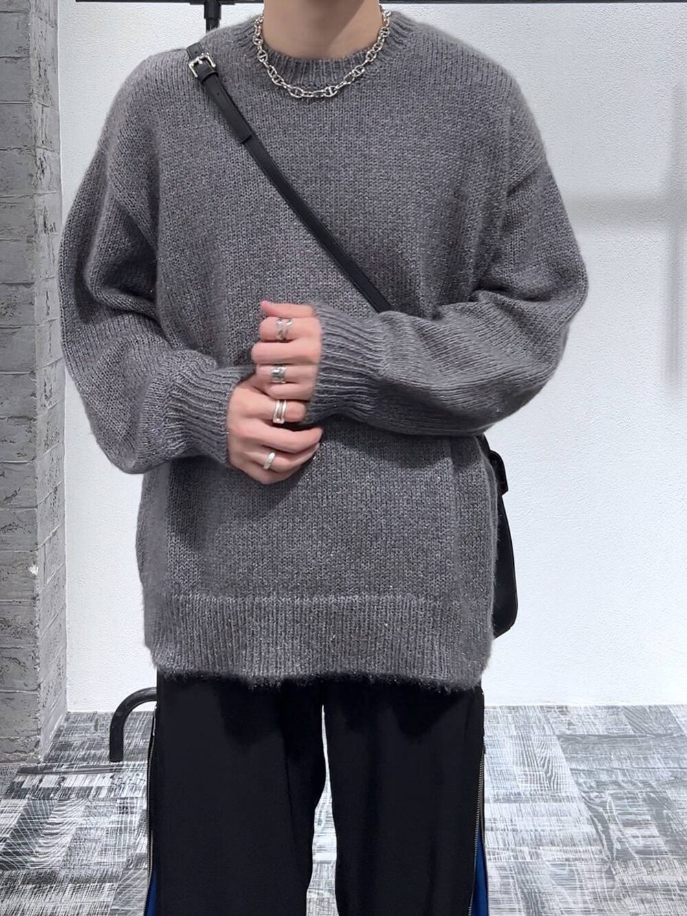 ブラック系のショルダーバッグ、ブラック系のブーツ、ブルー系のスラックスを着用したメンズの秋コーディネートの5枚目の写真