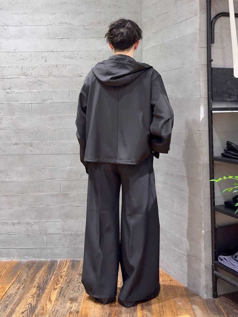 ブラック系のスラックス、ブラック系のブルゾン、ブラック系のスニーカーを着用したメンズの夏コーディネートの3枚目の写真