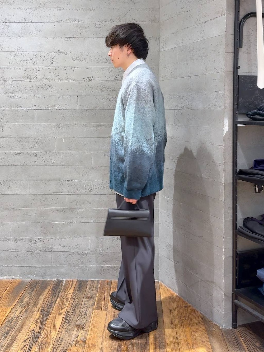 グリーン系のカーディガン/ボレロ、ブラック系のスニーカー、グレー系のスラックスを着用したメンズの冬コーディネートの4枚目の写真