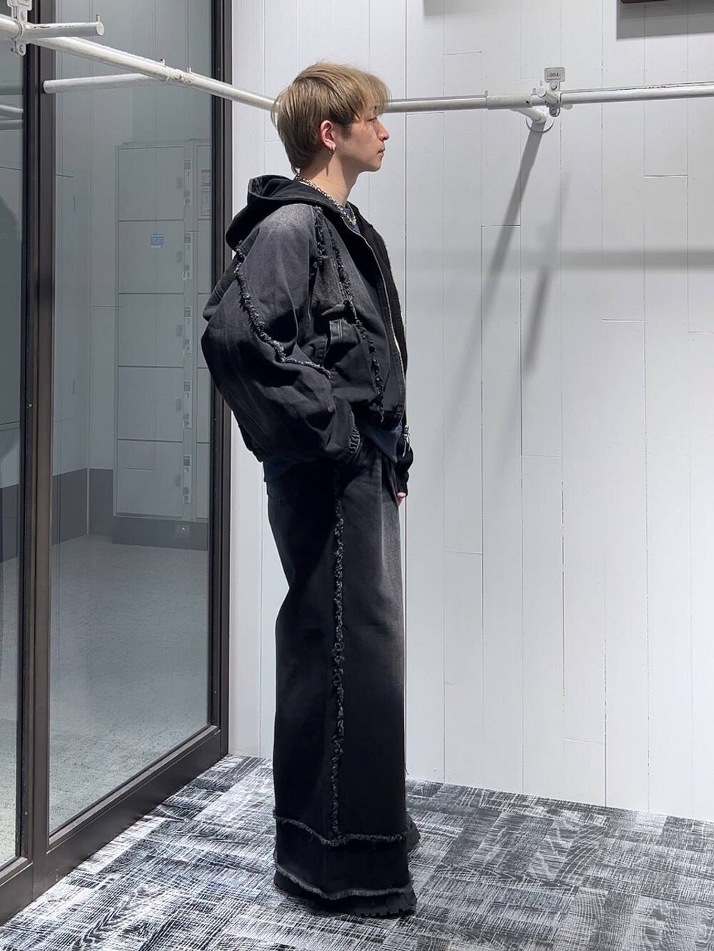 ブラック系のドレスシューズ、ブルー系のスウェット、ブラック系のデニムジャケットを着用したメンズの冬コーディネートの2枚目の写真