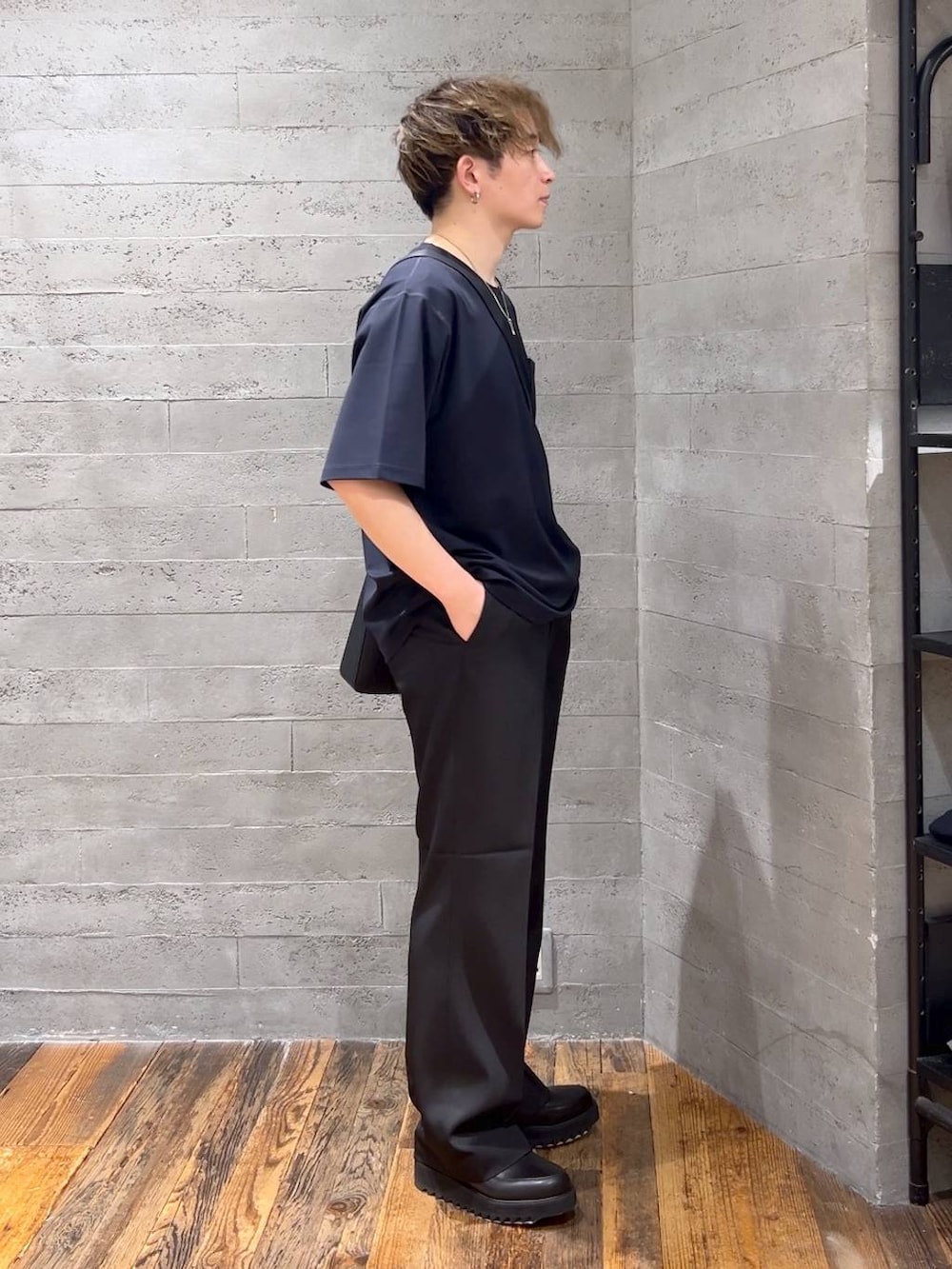 ブラック系のショルダーバッグ、ブルー系のTシャツ/カットソー、ブラック系のドレスシューズを着用したメンズの夏コーディネートの2枚目の写真