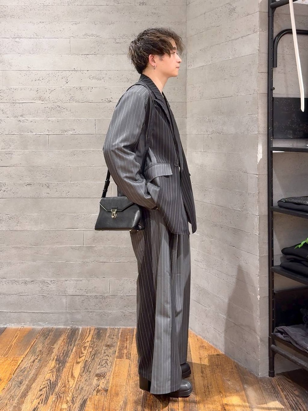 ブラック系のTシャツ/カットソー、ブラック系のブーツ、ブラック系のテーラードジャケットを着用したメンズの秋コーディネートの2枚目の写真