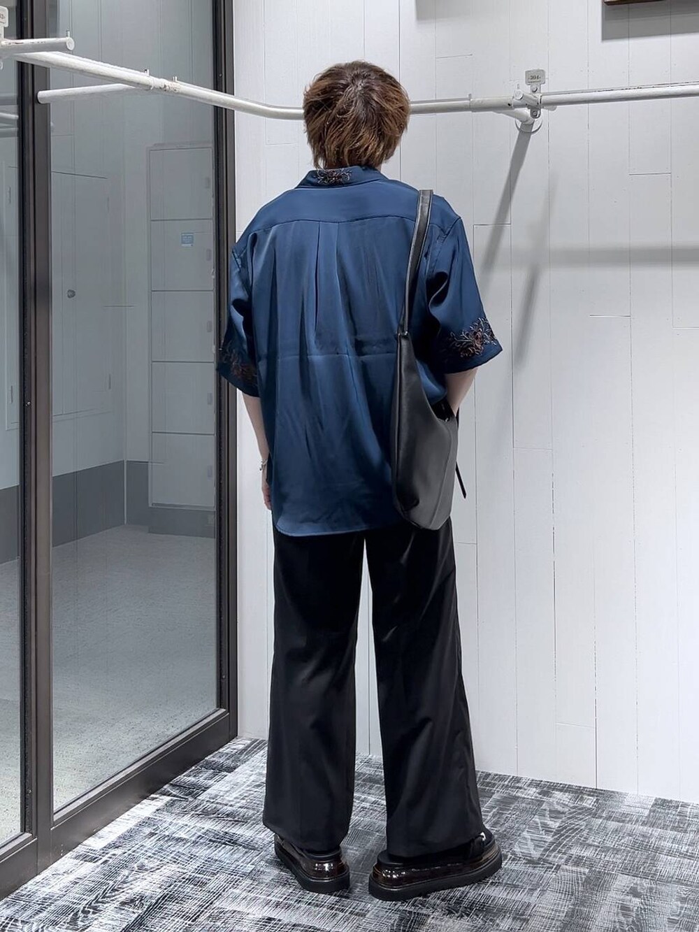 ブラック系のスラックス、ブラック系のサンダル、グレー系のTシャツ/カットソーを着用したメンズの春コーディネートの4枚目の写真