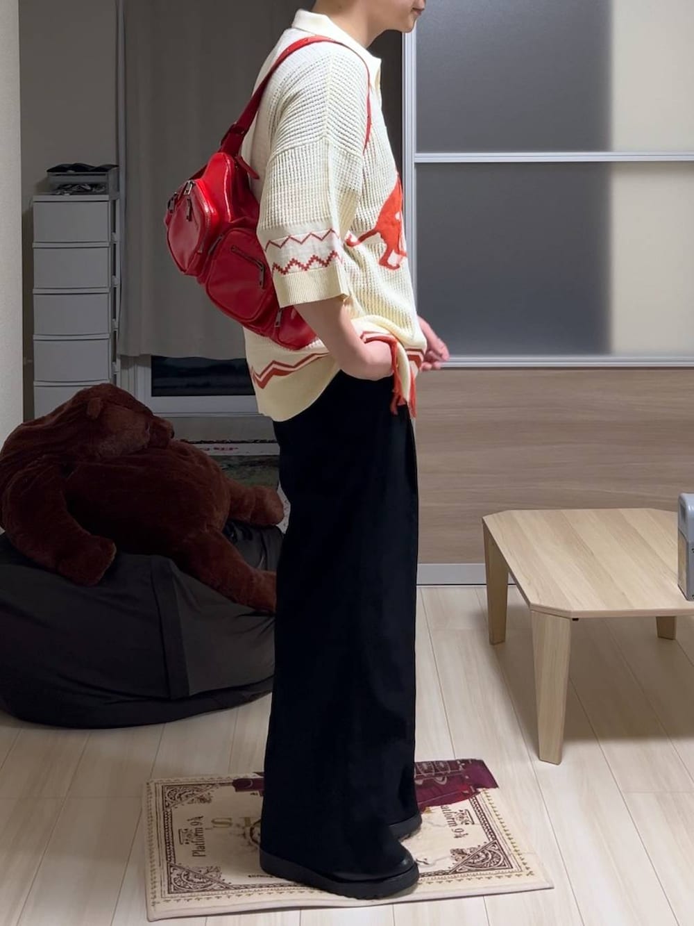 レッド系のショルダーバッグ、ブラック系のドレスシューズ、ブラック系のタンクトップを着用したメンズの夏コーディネートの2枚目の写真