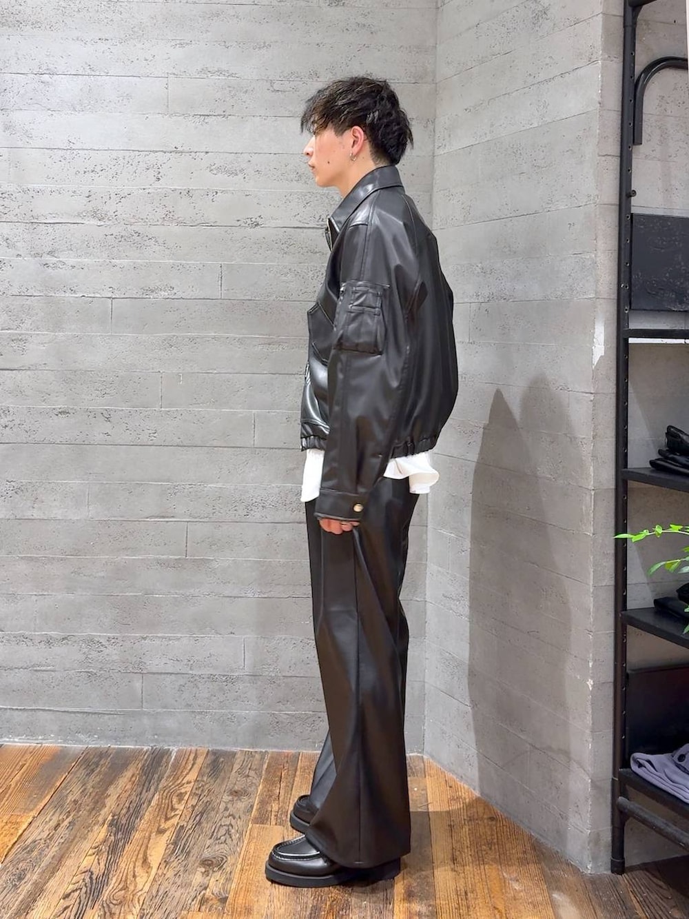 ブラック系のブルゾン、ブラック系のスラックス、ブラック系のローファーを着用したメンズの夏コーディネートの4枚目の写真