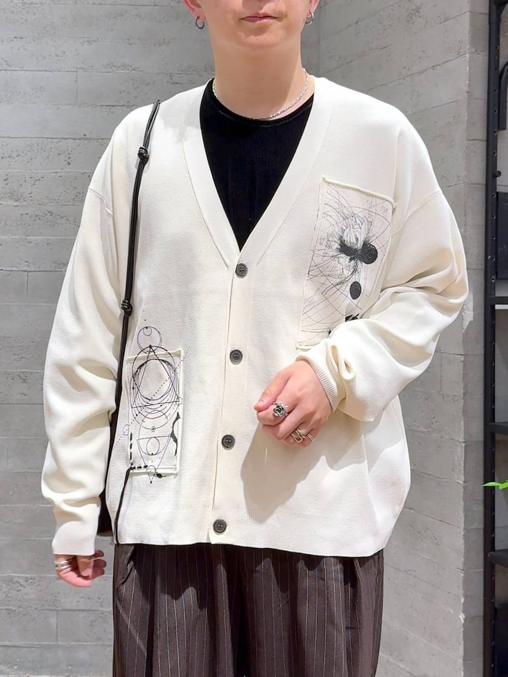 ブラック系のドレスシューズ、ブラック系のショルダーバッグ、ブラウン系のスラックスを着用したメンズの夏コーディネートの5枚目の写真