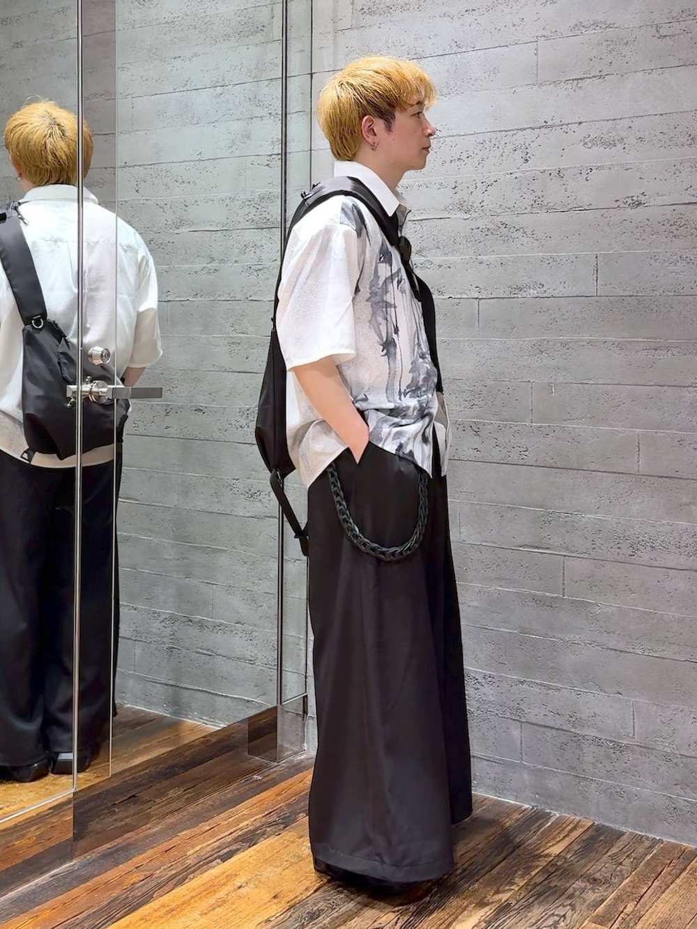 ブラック系のサンダル、ブラック系のショルダーバッグ、ブラック系のスラックスを着用したメンズの夏コーディネートの2枚目の写真