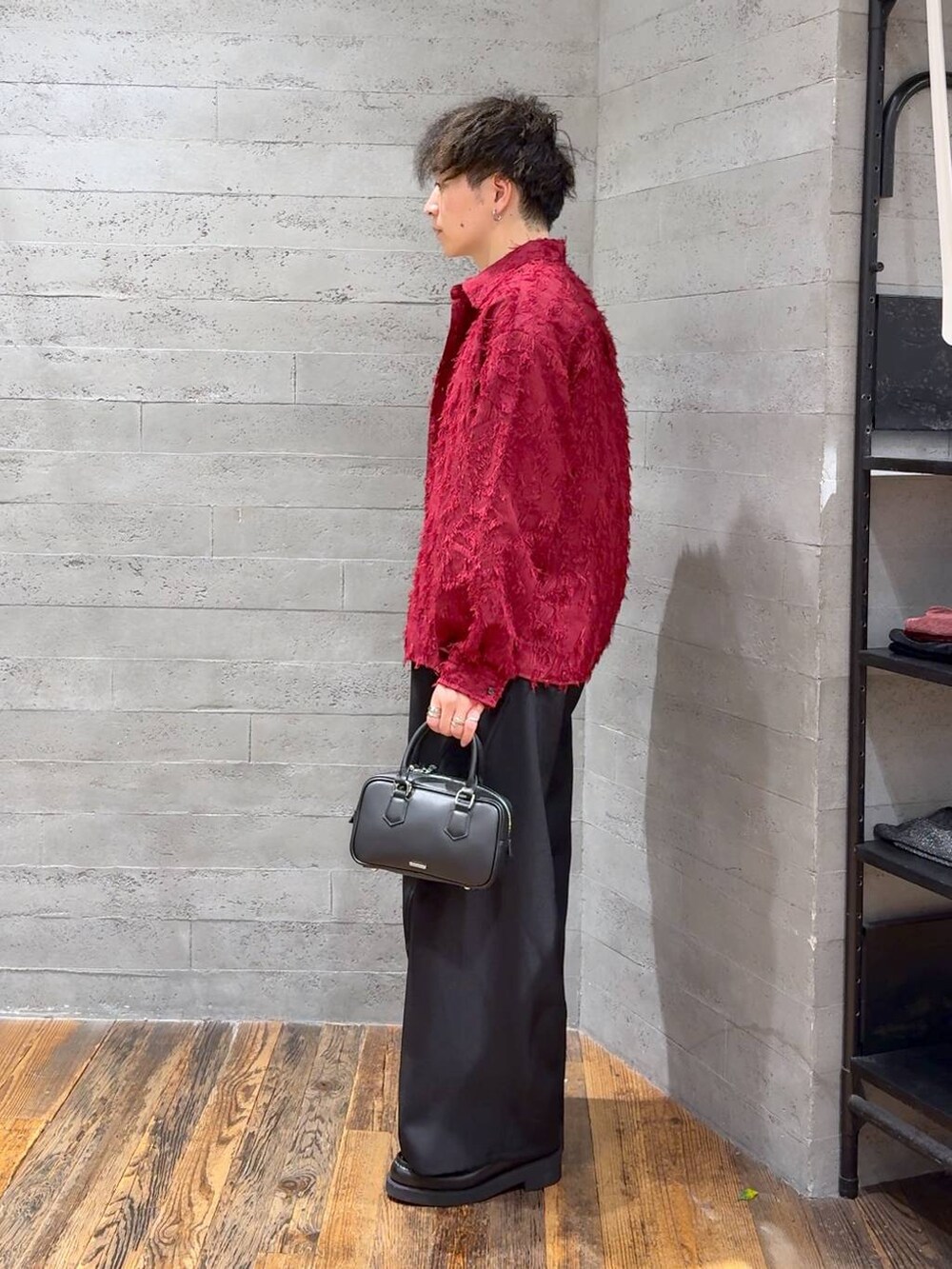 ブラック系のローファー、ブラック系のボストンバッグ、ブラック系のスラックスを着用したメンズの秋コーディネートの4枚目の写真