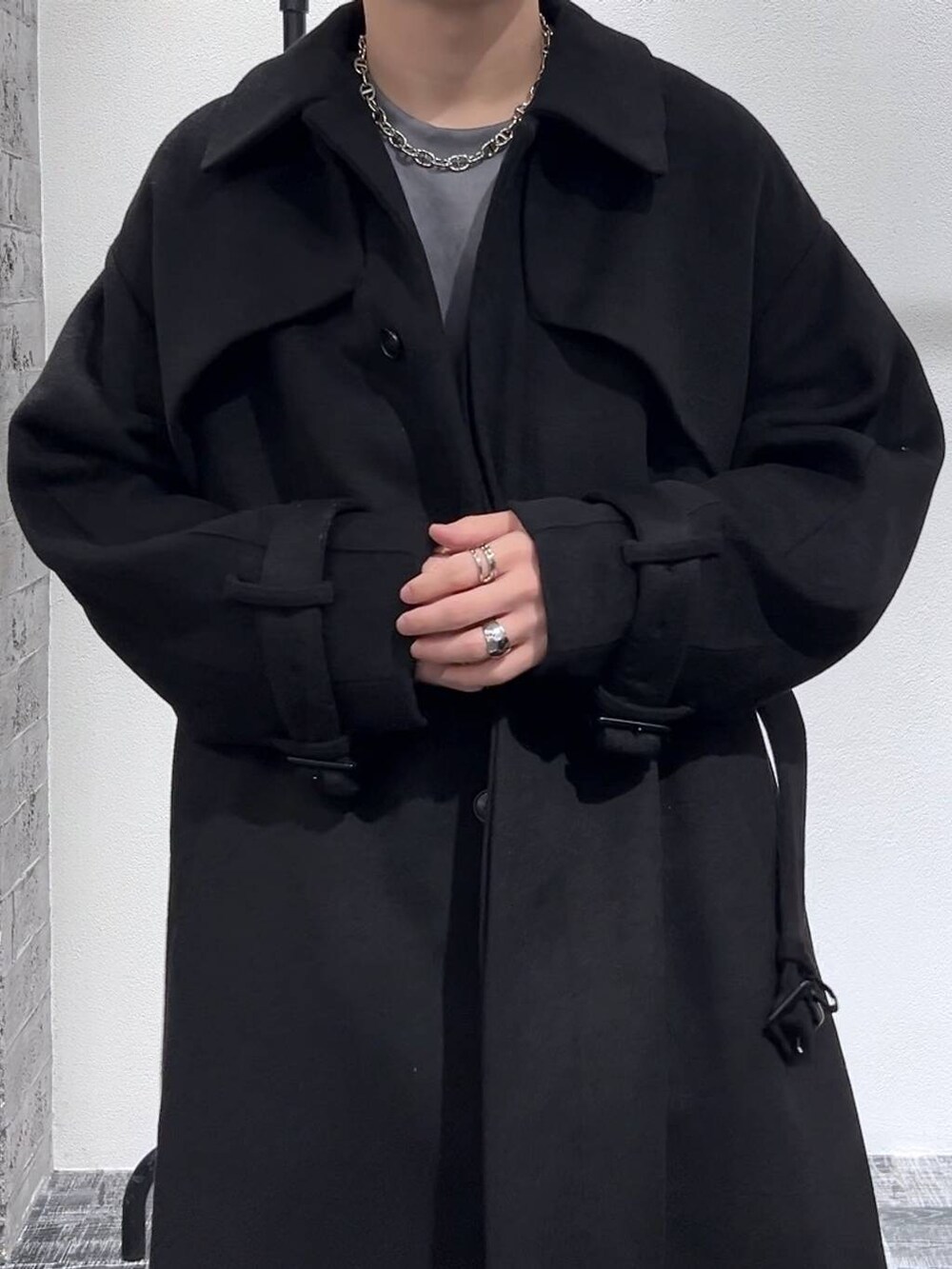 ブラック系のステンカラーコート、ブラック系のブーツ、グレー系のスウェットを着用したメンズの秋コーディネートの5枚目の写真