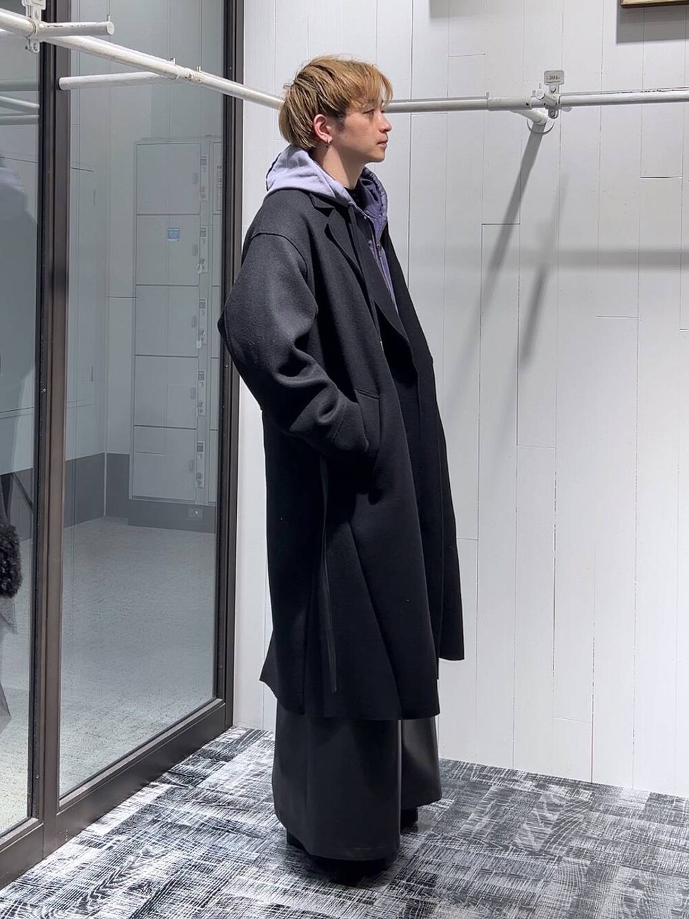 ブラック系のトレンチコート、ブラック系のその他パンツ、ブラック系のTシャツ/カットソーを着用したメンズの冬コーディネートの2枚目の写真