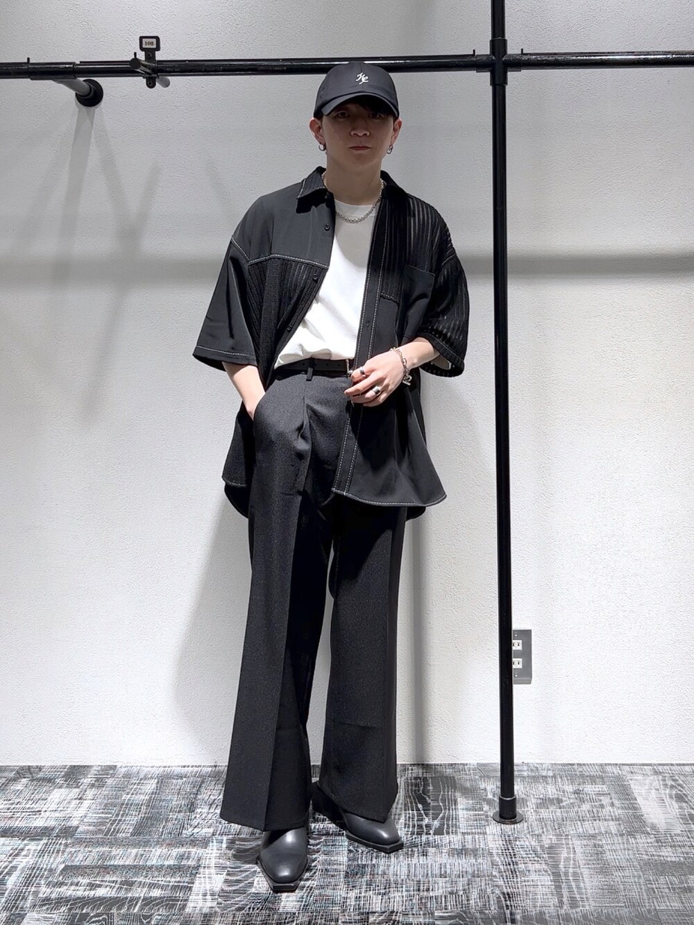 ブラック系のシャツ/ブラウス、ブラック系のスラックス、ブラック系のキャップを着用したメンズの春コーディネートの2枚目の写真