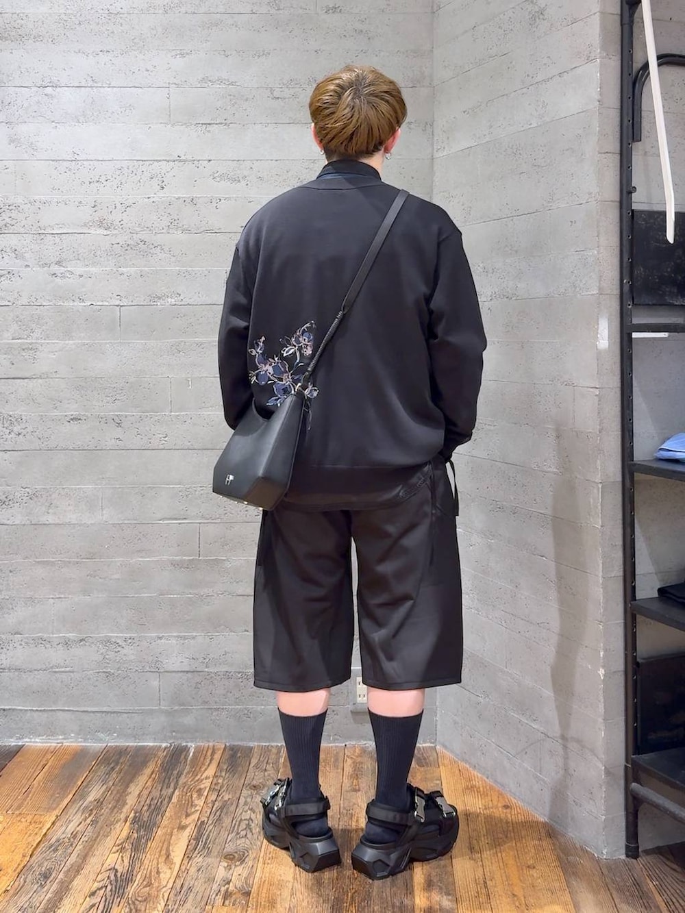 ブラック系のサンダル、ブラック系のスラックス、ブラック系のショルダーバッグを着用したメンズの春コーディネートの3枚目の写真