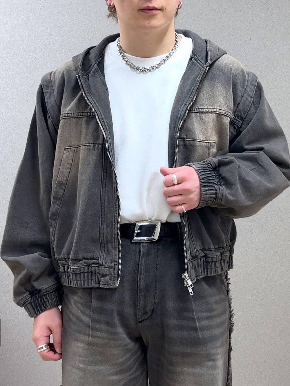 ブラウン系のデニムパンツ、ブラック系のドレスシューズ、シルバー系のネックレスを着用したメンズの冬コーディネートの5枚目の写真